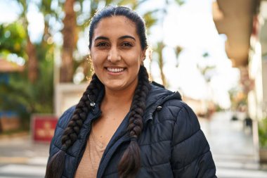 Sokakta kendine gülen genç İspanyol kadın.