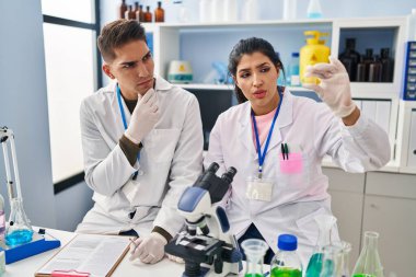 Erkek ve kadın bilim adamları laboratuardaki örnekleri analiz ediyor