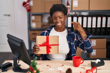 Afrika kökenli Amerikalı bir kadın Noel 'de küçük işletmelerde manikinlerin yanında durmuş mutlu ve gururlu bir şekilde kendini işaret ediyor. 