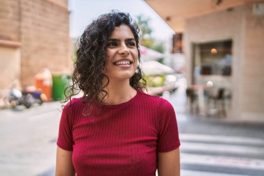 Sokakta kendine güvenen genç Latin kadın gülümsüyor
