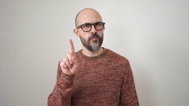 Genç, kel bir adam, izole edilmiş beyaz arka planda parmağını hareket ettirmiyor.