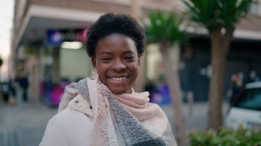 Genç Afrikalı Amerikalı kadın gülümsüyor. Kendine güveni tam.