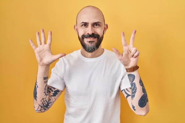 Mladý Hispánec Tetováním Stojící Nad Žlutým Pozadím Ukazující Ukazující Prsty — Stock fotografie