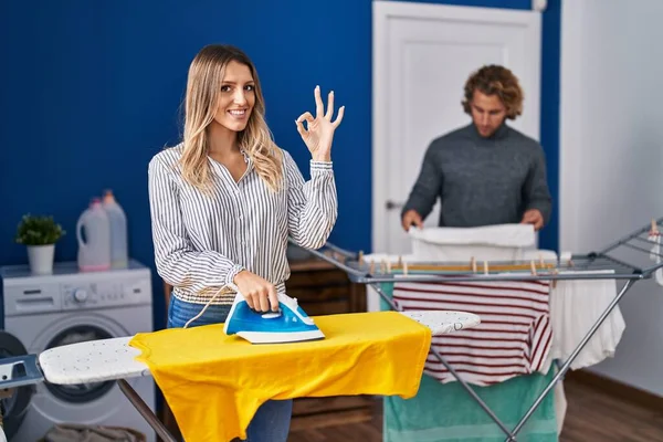 Couple Ironing Clothes Laundry Room Doing Sign Fingers Smiling Friendly — Stockfoto