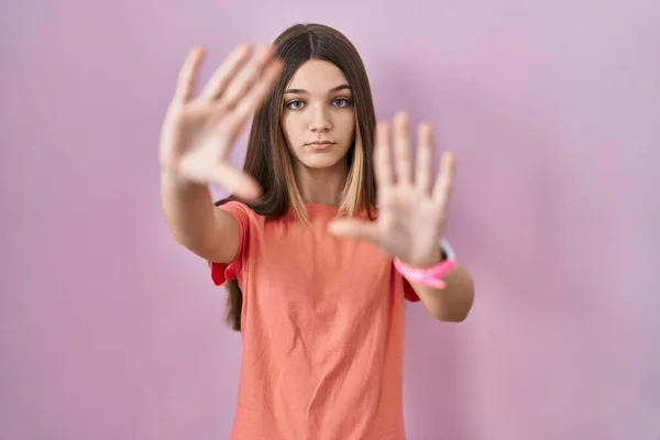 少女站在粉红的背景上 用手心和手指头 镜头透视画框 — 图库照片