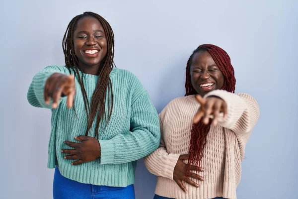 Две Африканки Стоящие Синем Фоне Смеющиеся Над Тобой Тычущие Пальцем — стоковое фото