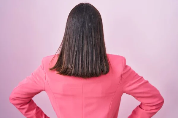 stock image Young hispanic woman wearing business clothes and glasses standing backwards looking away with arms on body 