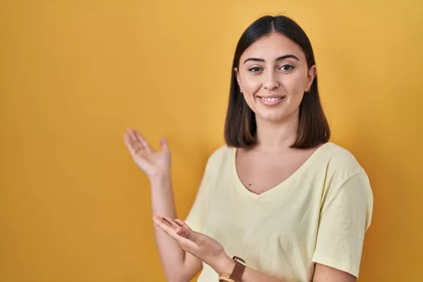 Chica Hispana Con Camiseta Casual Sobre Fondo Amarillo Invitando Entrar — Foto de Stock