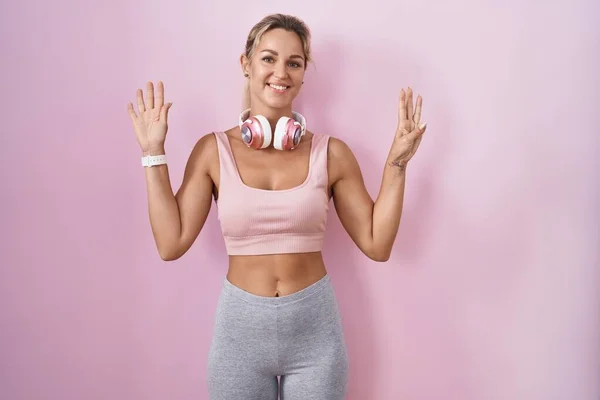 Young Blonde Woman Wearing Sportswear Headphones Showing Pointing Fingers Number — Stock Photo, Image