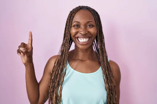 Африканская Американка Стоит Розовом Фоне Показывает Пальцем Номер Один Улыбаясь — стоковое фото