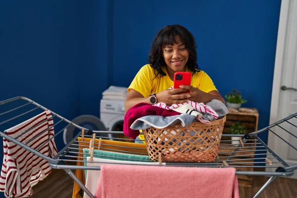 Ung Vacker Latinamerikansk Kvinna Med Smartphone Hängande Kläder Klädstreck Tvättstuga — Stockfoto