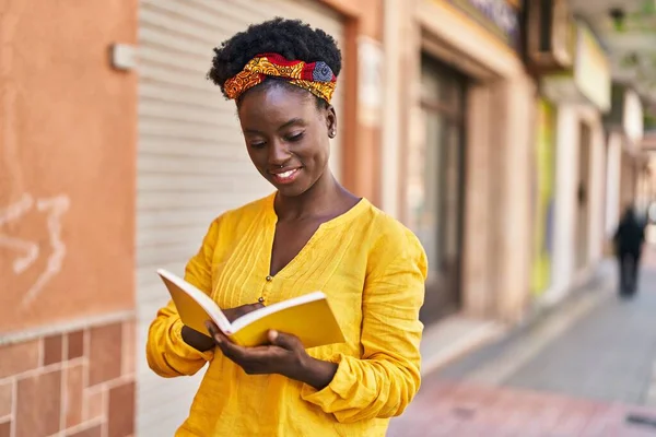 年轻的非洲裔美国女人微笑着 自信地在街上看书 — 图库照片