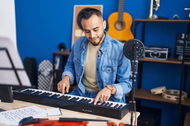 Genç İspanyol müzisyen müzik stüdyosunda piyano çalıyor.