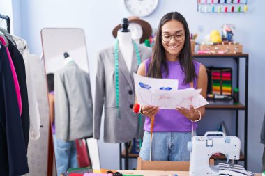 Genç, güzel İspanyol kadın terzi dükkanında kendine güvenen, kendine güvenen bir elbise tasarımcısı.
