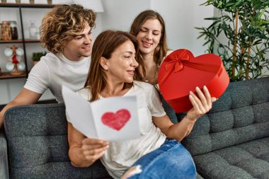 Anne ve çift evde hediye kartı ve kalp ile sürpriz yapıyorlar.