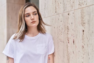 Young woman standing with relaxed expression at street