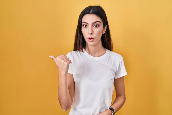 Young Beautiful Woman Standing Yellow Background Surprised Pointing Hand Finger — Stock Photo, Image