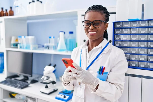 Африканская Американка Ученый Улыбается Уверенно Используя Смартфон Лаборатории — стоковое фото