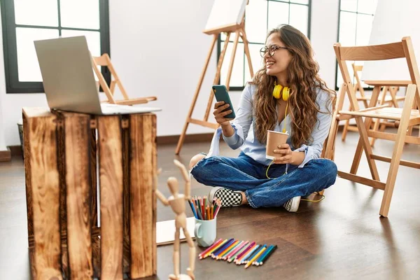 年轻美丽的惊慌失措的女艺人在艺术工作室用智能手机喝咖啡 — 图库照片