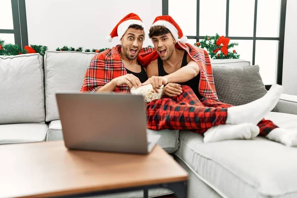 二つのヒスパニック男性カップル見ますムービー座っていますクリスマス装飾によって家 — ストック写真