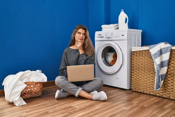 Young Woman Waiting Laundry Using Laptop Serious Face Thinking Question — Stock Photo, Image