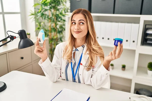 Young Blonde Doctor Woman Holding Medicine Products Breath Better Smiling — Stock Photo, Image