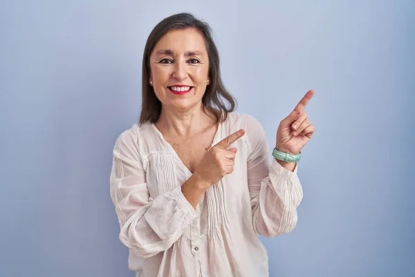 Medelåldern Latinamerikansk Kvinna Står Över Blå Bakgrund Ler Och Tittar — Stockfoto