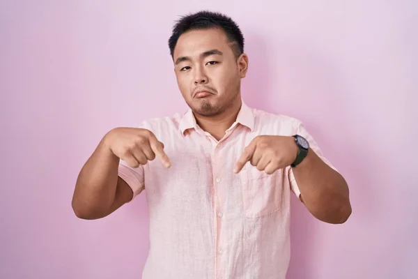Китайский Молодой Человек Стоящий Розовом Фоне Указывая Грустный Расстроенный Вид — стоковое фото