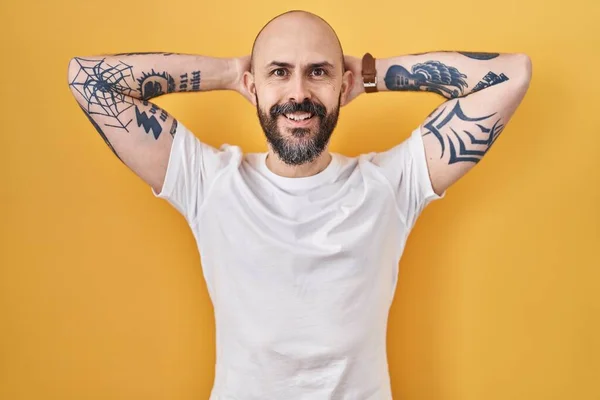 Jovem Hispânico Com Tatuagens Sobre Fundo Amarelo Relaxante Alongamento Braços — Fotografia de Stock