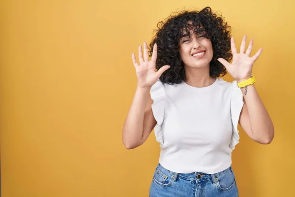 年轻的中东女人站在黄色的背景上 带着自信和快乐的微笑 用十号手指指指着 — 图库照片