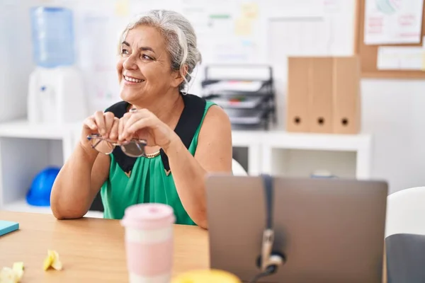 オフィスのテーブルの上で自信を持って笑顔中年白髪の女性ビジネスワーカー — ストック写真