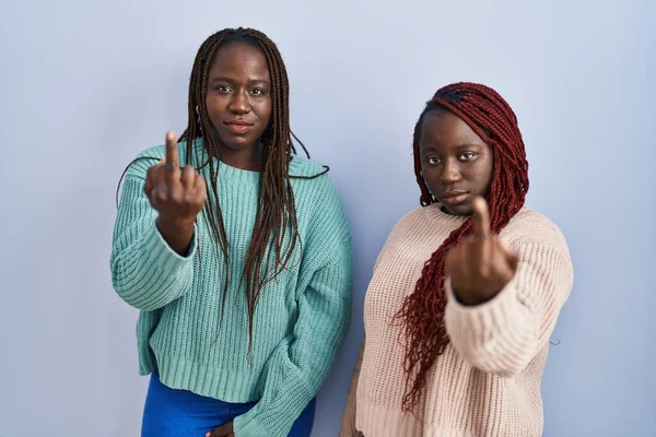 Two African Woman Standing Blue Background Showing Middle Finger Impolite — стоковое фото