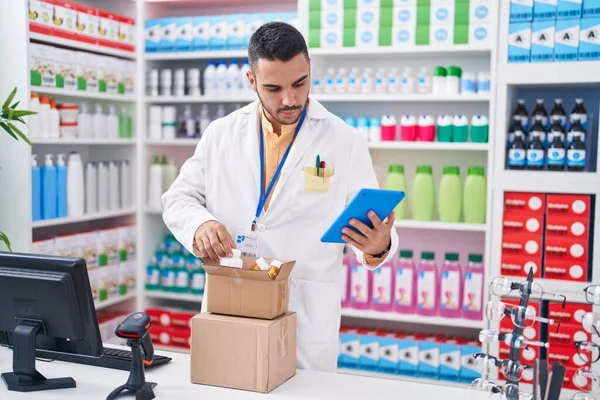 Young Hispanic Man Pharmacist Using Touchpad Holding Pills Bottle Pharmacy — Stock Photo, Image