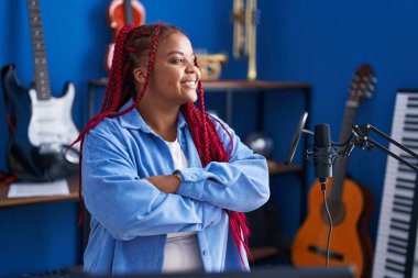 African american woman artist smiling confident standing with arms crossed gesture at music studio