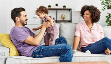 Couple and daughter smiling confident hugging each other at home