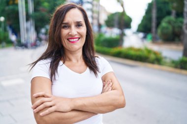 Sokakta kollarını kavuşturmuş genç, güzel İspanyol bir kadın.