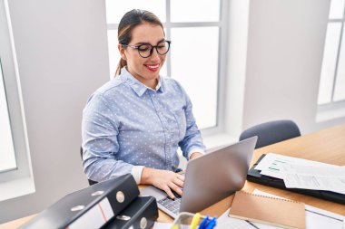 Young beautiful hispanic woman business worker using laptop working at office