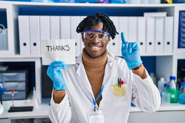 幸せな顔をしたアイデアや質問を指差す指で笑顔で研究室で働いている若いアフリカの男 ナンバーワン — ストック写真