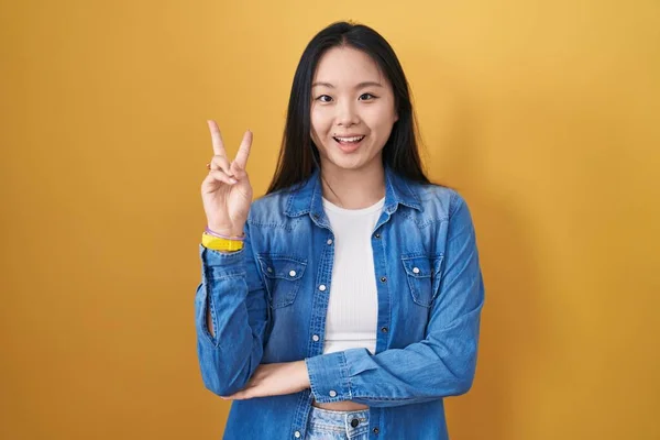 Mladá Asiatka Stojící Nad Žlutým Pozadím Usmívající Veselou Tváří Mrkající — Stock fotografie