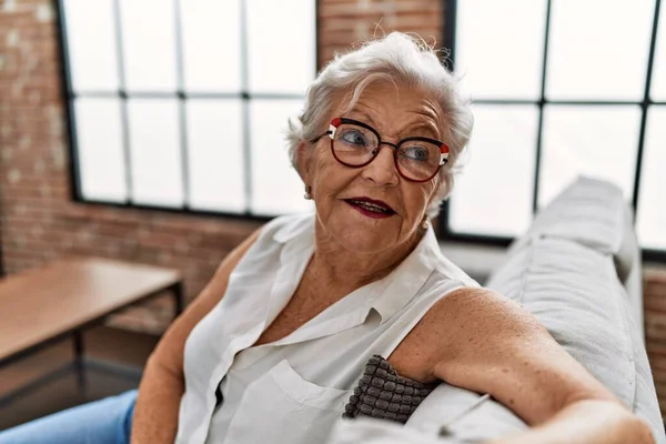 Yaşlı Kır Saçlı Gülümseyen Bir Kadın Evdeki Koltukta Oturuyor — Stok fotoğraf