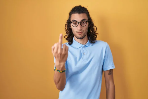 Young Hispanic Man Standing Yellow Background Showing Middle Finger Impolite — Zdjęcie stockowe
