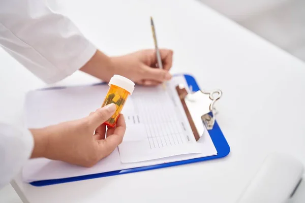 Young Beautiful Hispanic Woman Pharmacist Holding Pills Bottle Writing Document — 图库照片