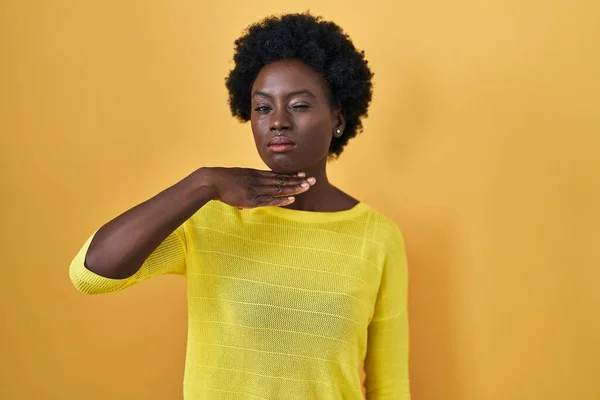 アフリカの若い女性はナイフで手で喉を切断黄色のスタジオの上に立って 激怒暴力で侵略を脅かす — ストック写真