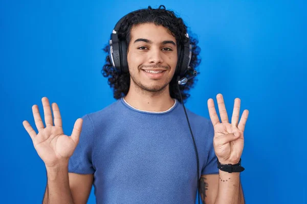 머리가 곱슬곱슬 아메리카 남자가 헤드폰을 음악을 자신감 행복하게 웃으면서 손가락으로 — 스톡 사진