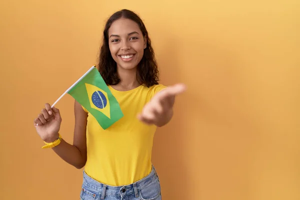 Young Hispanic Woman Holding Brazil Flag Smiling Cheerful Offering Palm — Stock Photo, Image