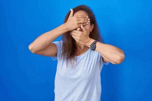 Mavi Arka Planda Duran Esmer Kadın Gözlerini Ağzını Elleriyle Kapatıyor — Stok fotoğraf