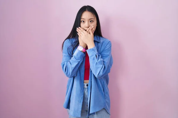 年轻的亚洲女人站在粉红的背景上 用双手捂住嘴 感到震惊 因为她犯错了 秘密概念 — 图库照片