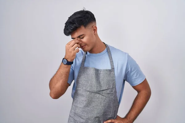 Hispanic Ung Man Bär Förkläde Över Vit Bakgrund Trött Gnugga — Stockfoto