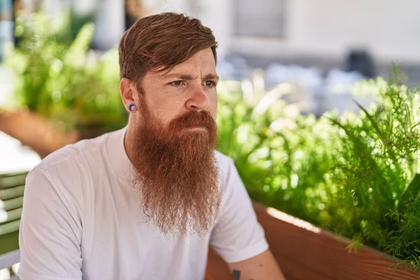 Young Redhead Man Sitting Table Serious Expression Coffee Shop Terrace — Stockfoto