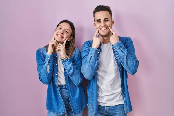 Young Hispanic Couple Standing Pink Background Smiling Open Mouth Fingers — Stock Photo, Image